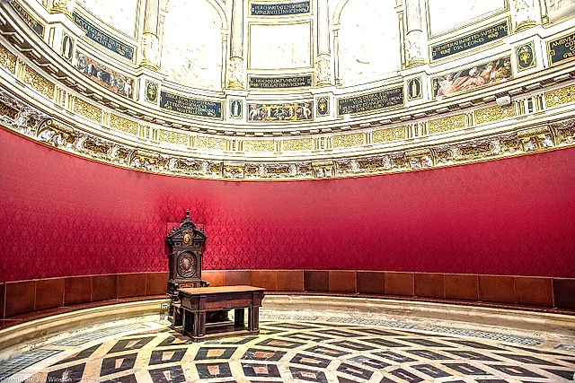 La Sala Capitolare ellittica con le pareti rosse e il pavimento in marmo