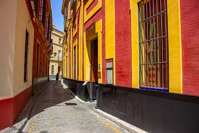 Una stradina del quartiere di Santa Cruz con pareti gialle e rosse