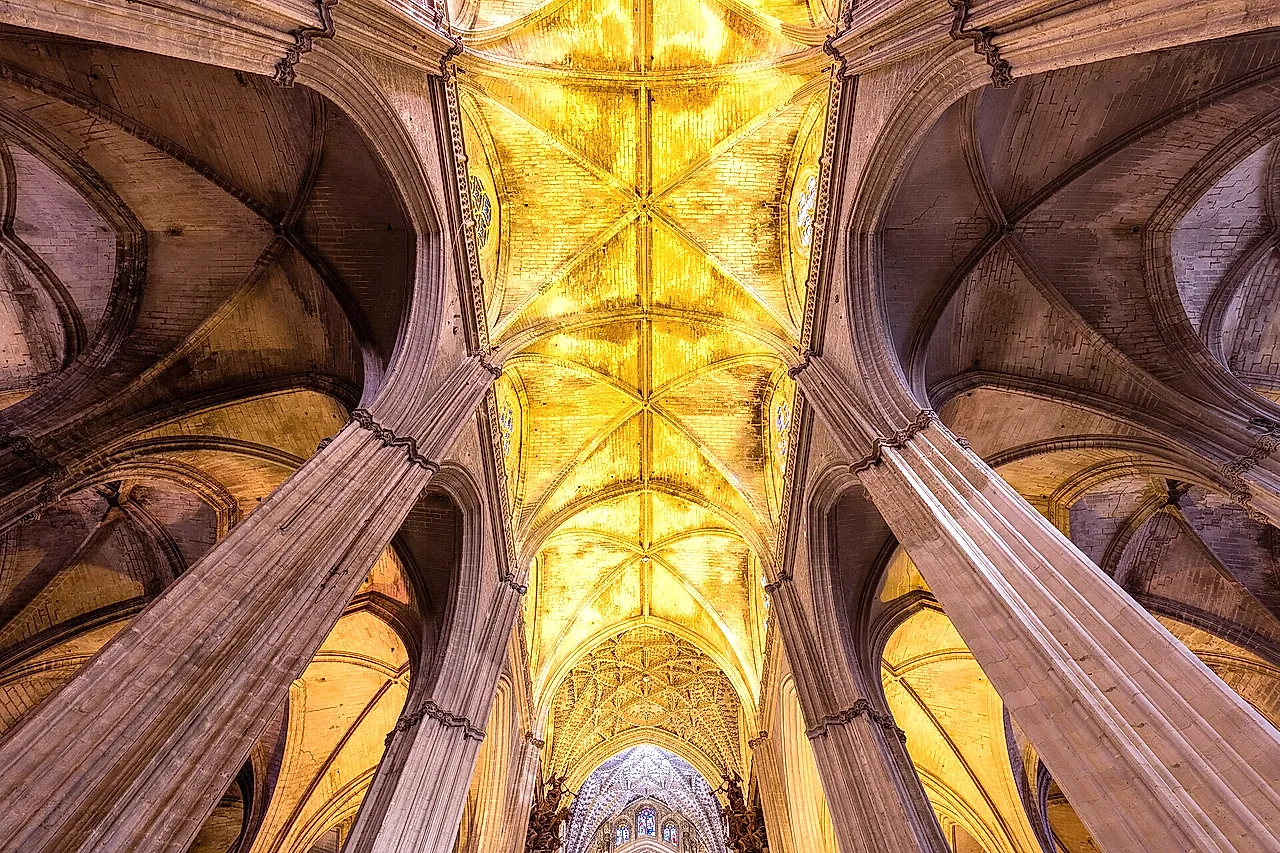 Volte gotiche a costoloni illuminate d'oro all'interno della cattedrale