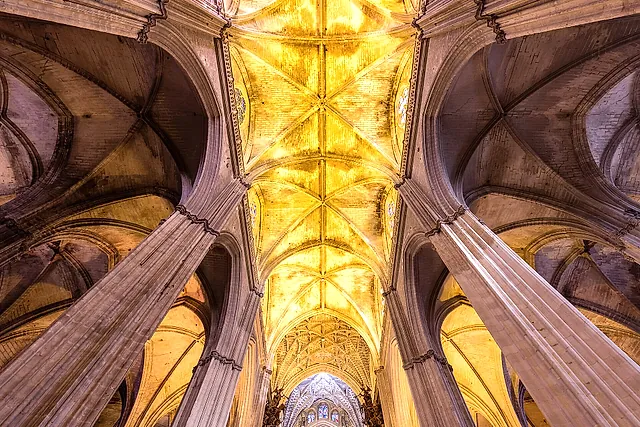 Volte gotiche a costoloni illuminate d'oro all'interno della cattedrale